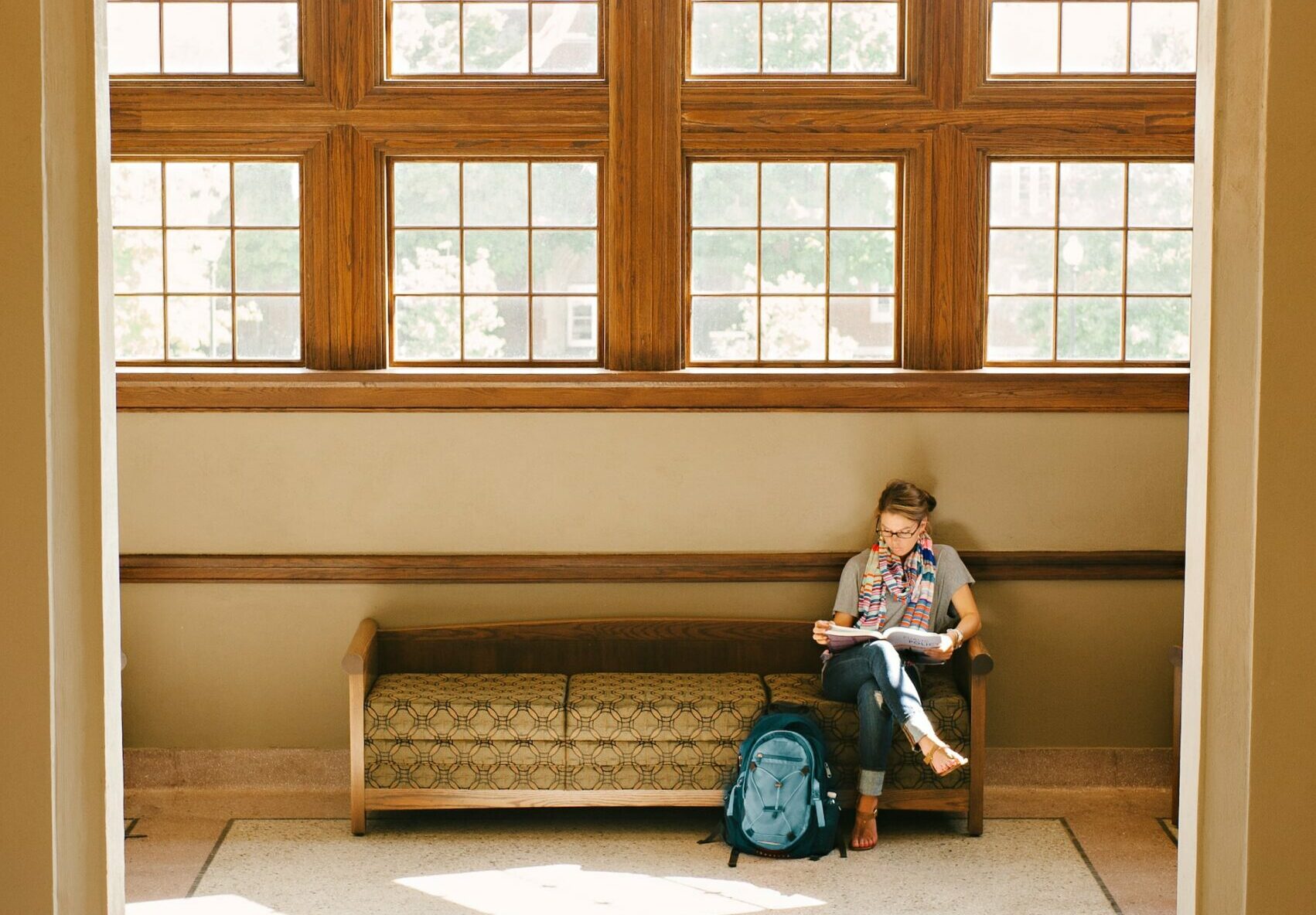 women sitting in hallway reading a book
