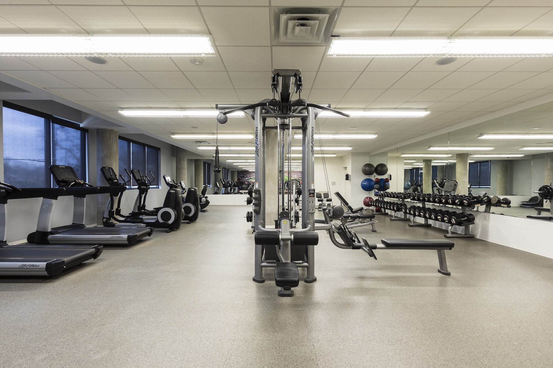 Fitness room with weight lifting machines and dumbbells, treadmills, elliptical machines and sitting bike