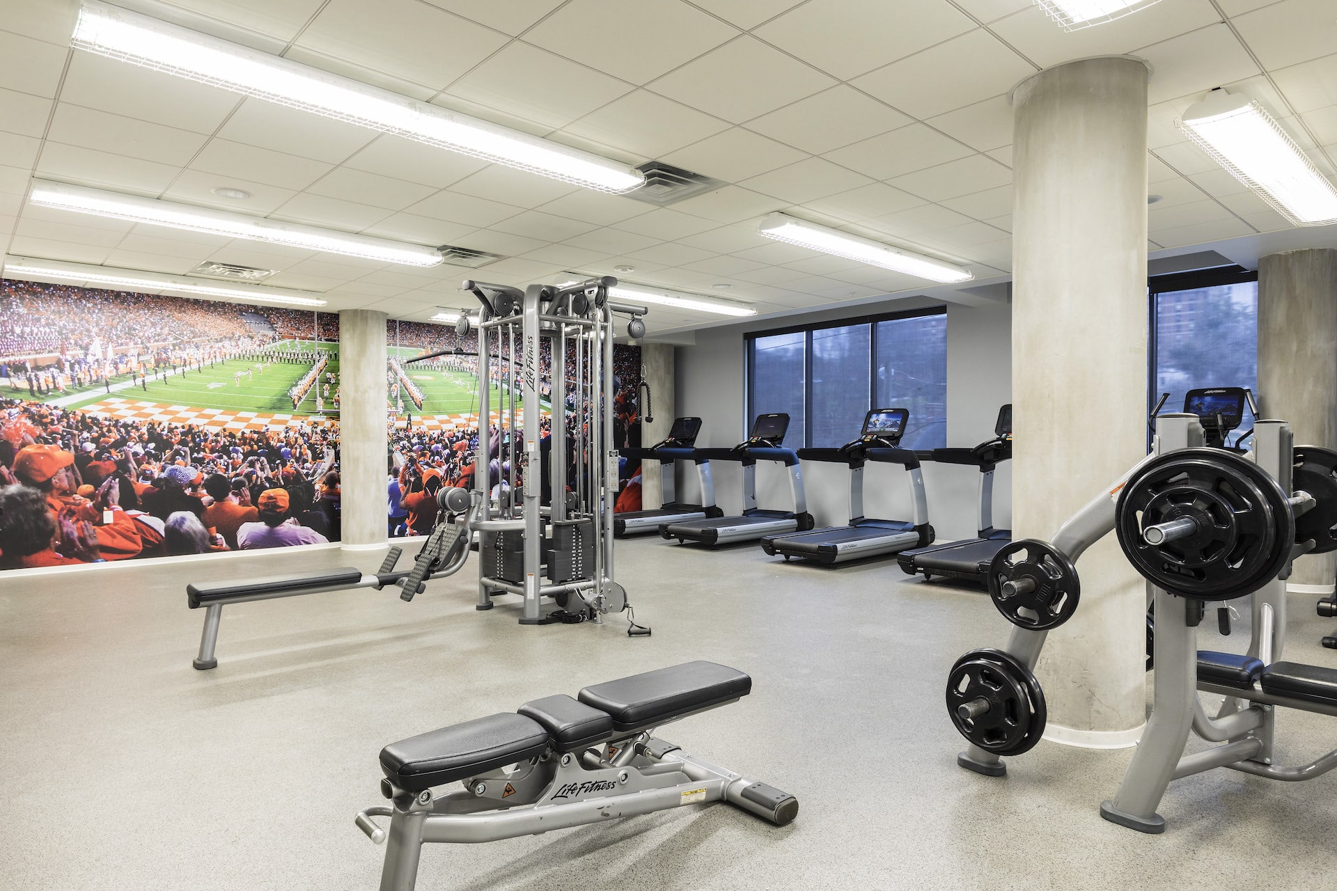 Fitness room with weight lifting equipment, treadmills, and bench